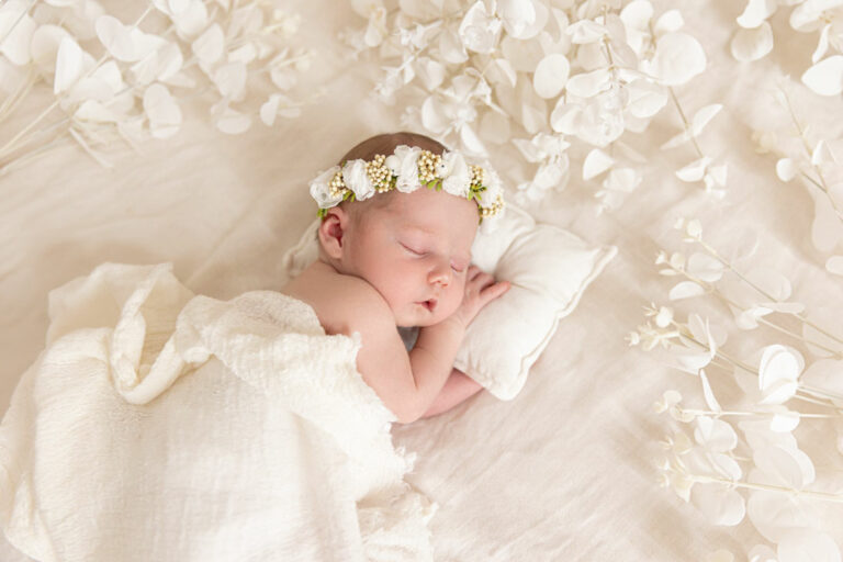 photo de bébé nouveau né dans un décors blanc